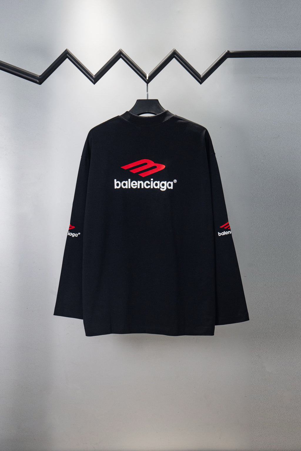 Black long-sleeve T-shirt with red Balenciaga logo, side view