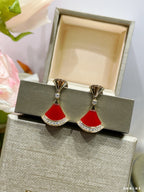 Pair of gold-tone earrings with red fan-style drops and sparkling rhinestone trim