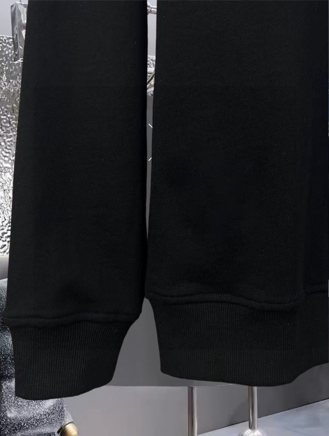 Black sweatshirt lower sleeves and hem with ribbed knit cuffs