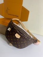 Louis Vuitton monogram crossbody bag with long strap and front plaque, brown, angled view.