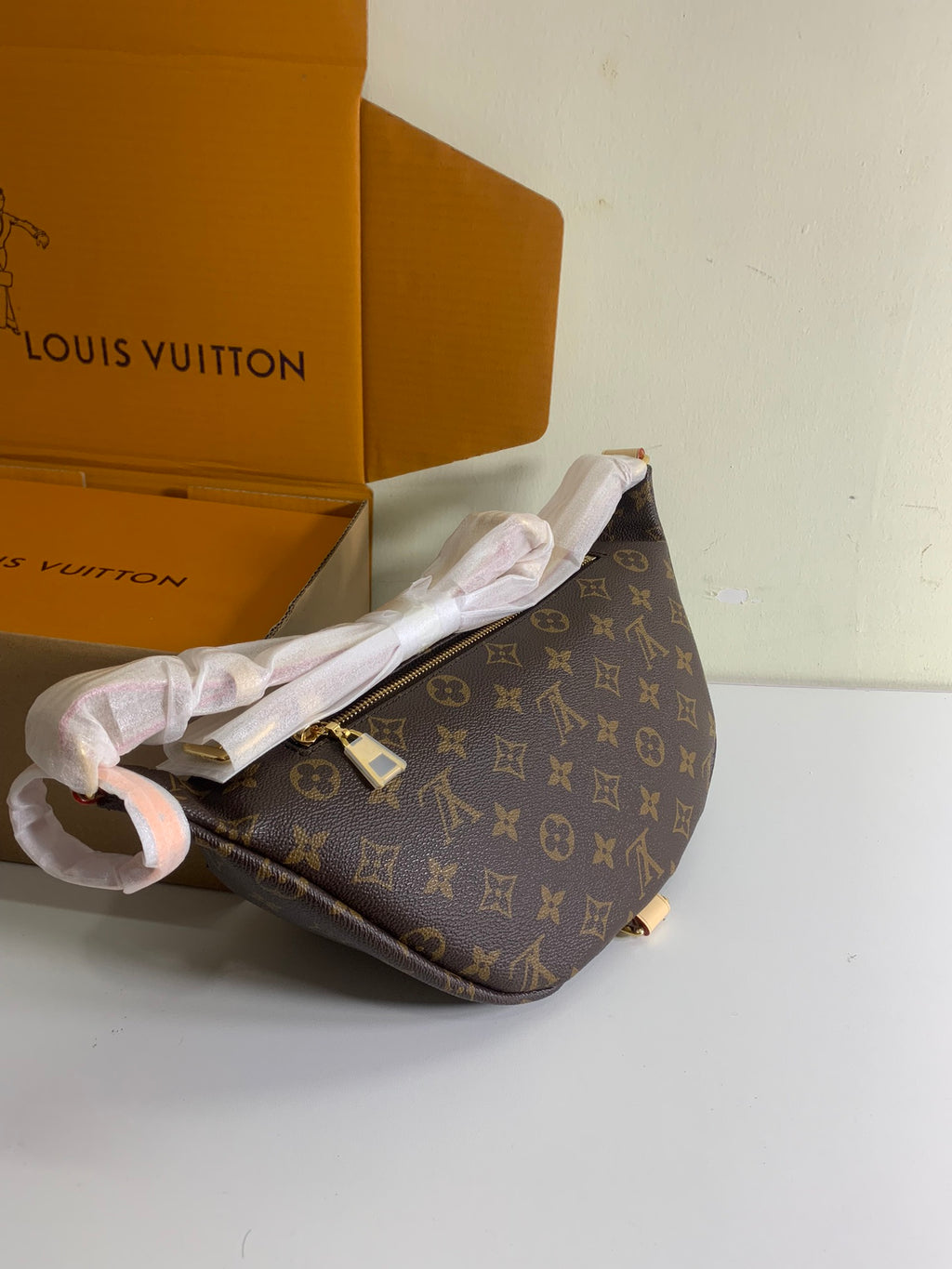 Louis Vuitton monogram crossbody bag with adjustable strap, brown coated canvas, angled view.
