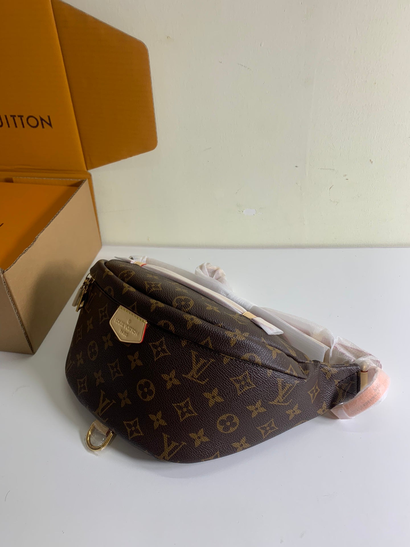 Louis Vuitton monogram crossbody bag with strap and flap, brown coated canvas, side view.