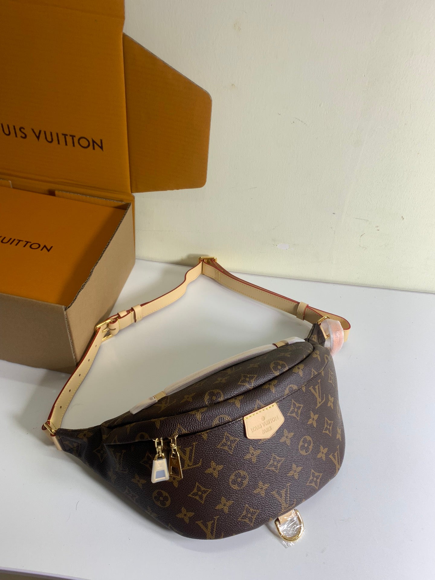 Louis Vuitton monogram crossbody bag with tan leather trim and gold zipper, adjustable strap