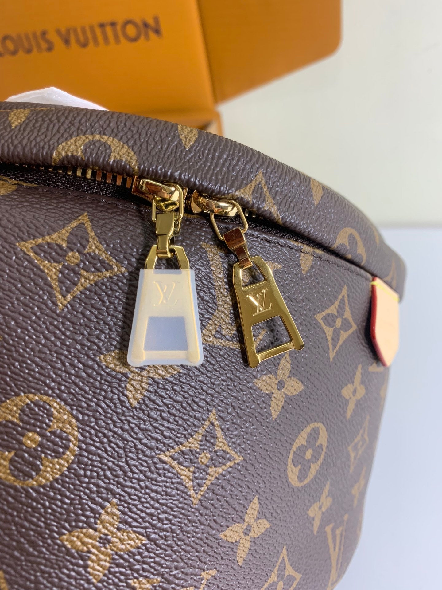 Louis Vuitton monogram bag top zipper with gold hardware and hanging tag, brown.