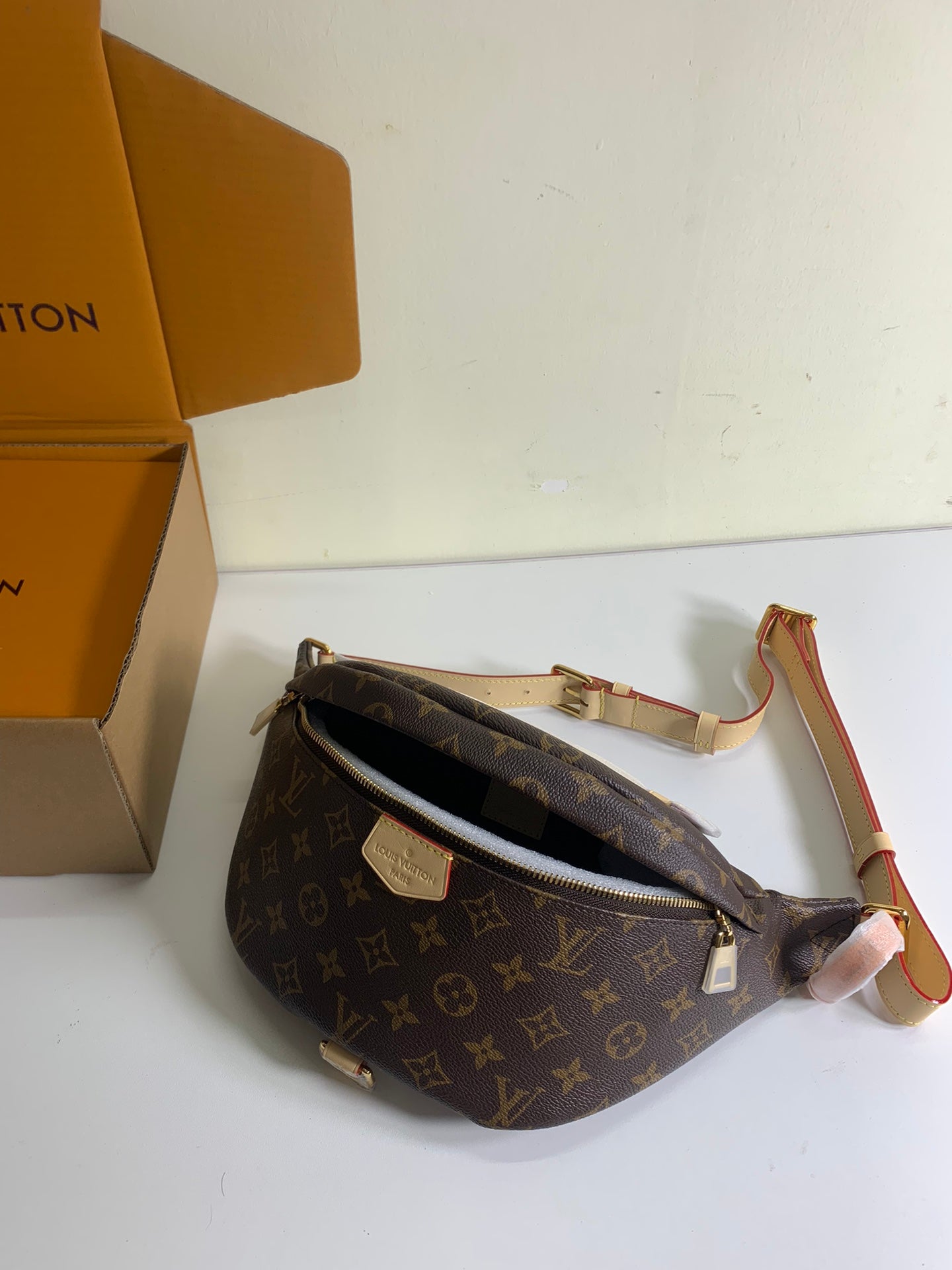 Louis Vuitton monogram crossbody bag with zip opening, tan strap and gold hardware