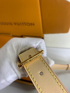 Louis Vuitton leather wristlet strap with gold clasp and monogram charm, tan