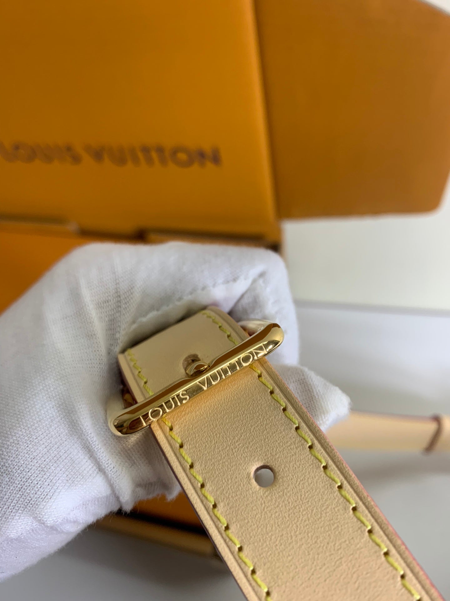 Louis Vuitton leather wristlet strap with gold clasp and monogram charm, tan