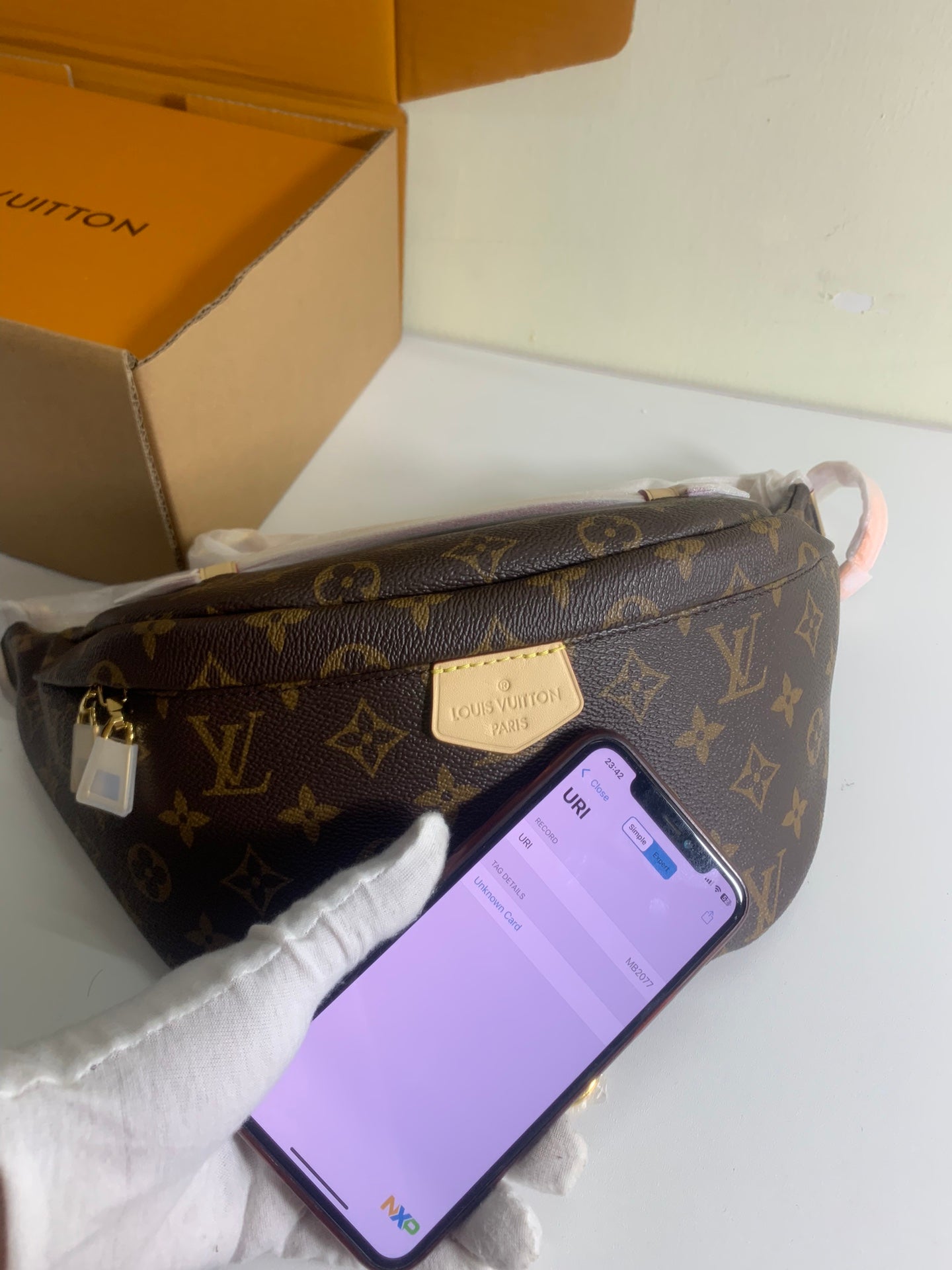 Louis Vuitton monogram crossbody bag with gold front plaque and adjustable strap, brown.