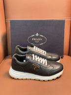 PRADA low-top sneakers, dark leather with white laces, chunky white sole with yellow edge