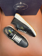 PRADA low-top sneakers, dark leather with white laces, off-white sole, yellow tread