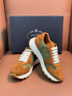 Unisex Prada sneakers with tan suede uppers, green side panels, white laces, chunky sole.