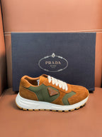 Unisex Prada low-top sneakers, tan suede with green panels, white laces and sole.