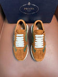 Unisex Prada sneakers in tan suede with green panels, white laces and rubber sole.