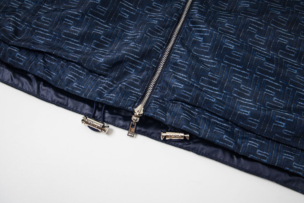 Patterned navy jacket hem with elastic trim and zipper pull details