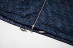 Patterned navy jacket hem with elastic trim and zipper pull details