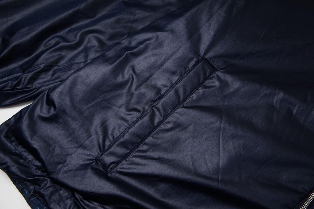 Navy hooded jacket with diamond quilting stitch detail and diagonal paneling