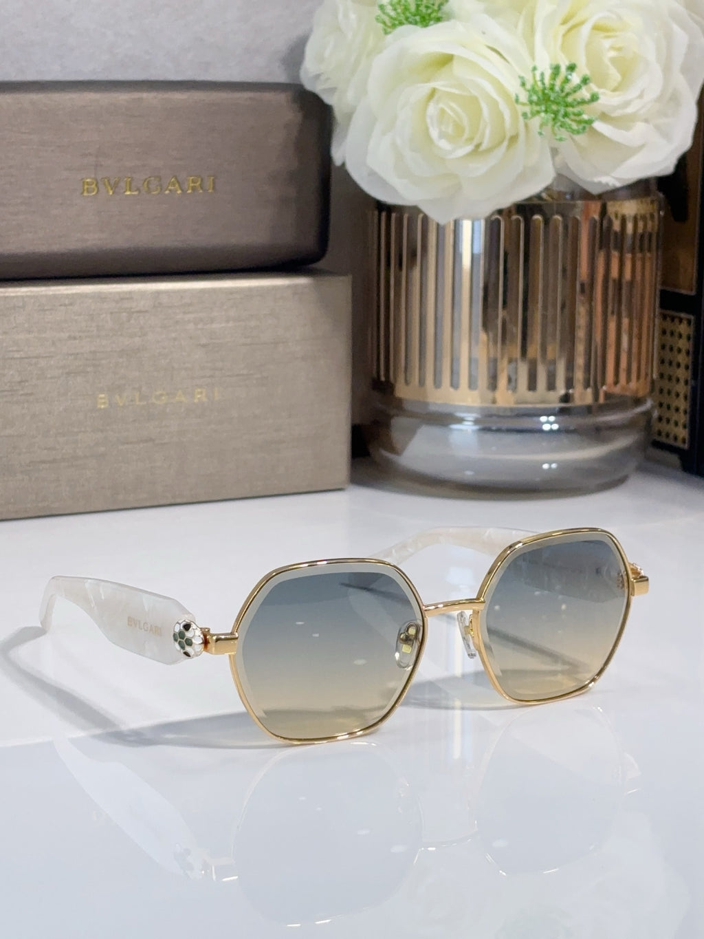 Gold round sunglasses with pale yellow tinted lenses and logo on arms
