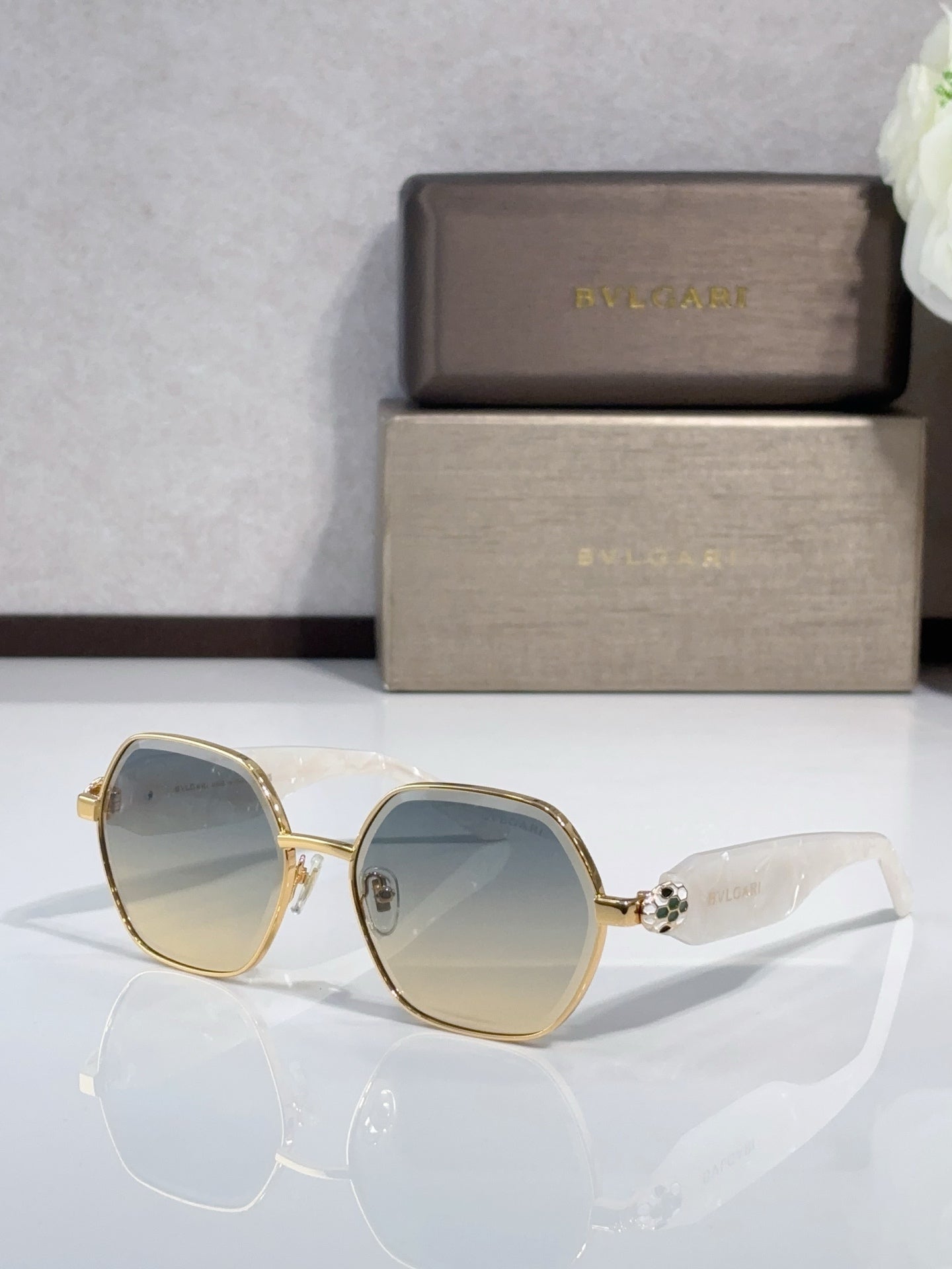 Light blue sunglasses with gold round frames and logo on arms