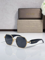 Dark navy sunglasses with gold-tone round frames and logo on arms