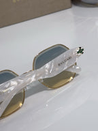Gold sunglasses arm with green jewel detail and BVLGARI logo on temple