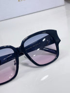 Dior sunglasses, close-up of navy frame and pink-tinted lens with metal logo
