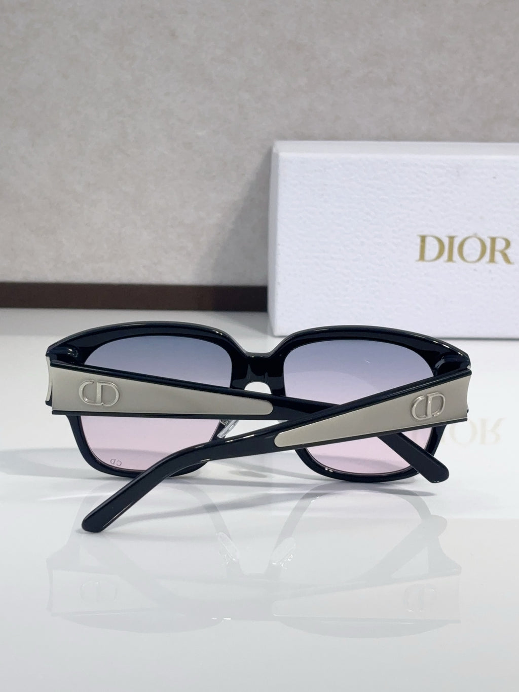 Dior sunglasses, navy cat-eye frame with mauve lenses and gold logo on temples
