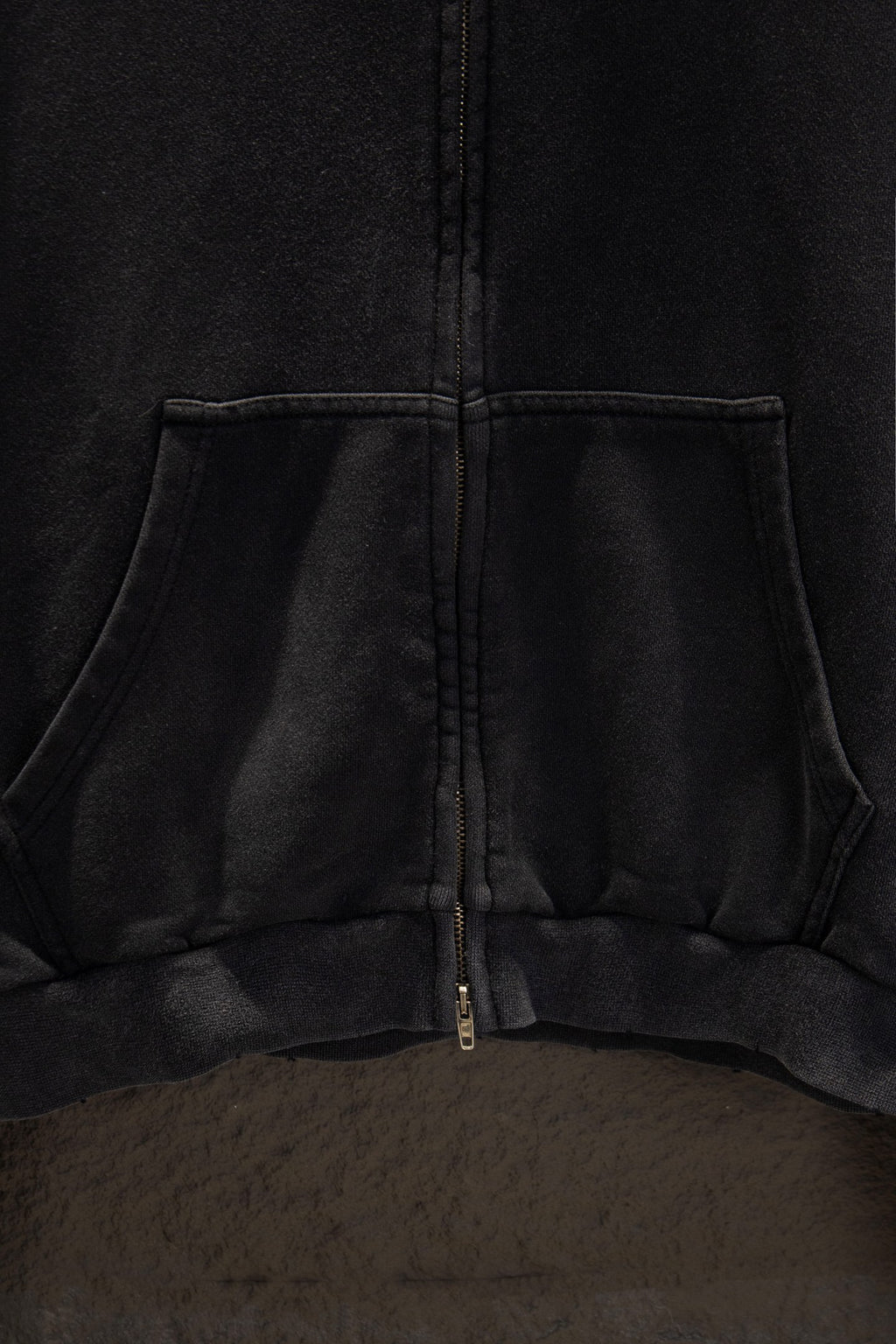 Balenciaga long zip-up hoodie hem area with center zipper and kangaroo pocket seam.