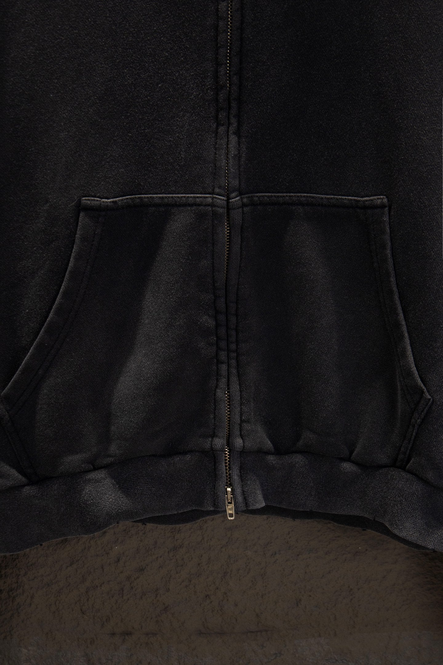 Balenciaga long zip-up hoodie hem area with center zipper and kangaroo pocket seam.