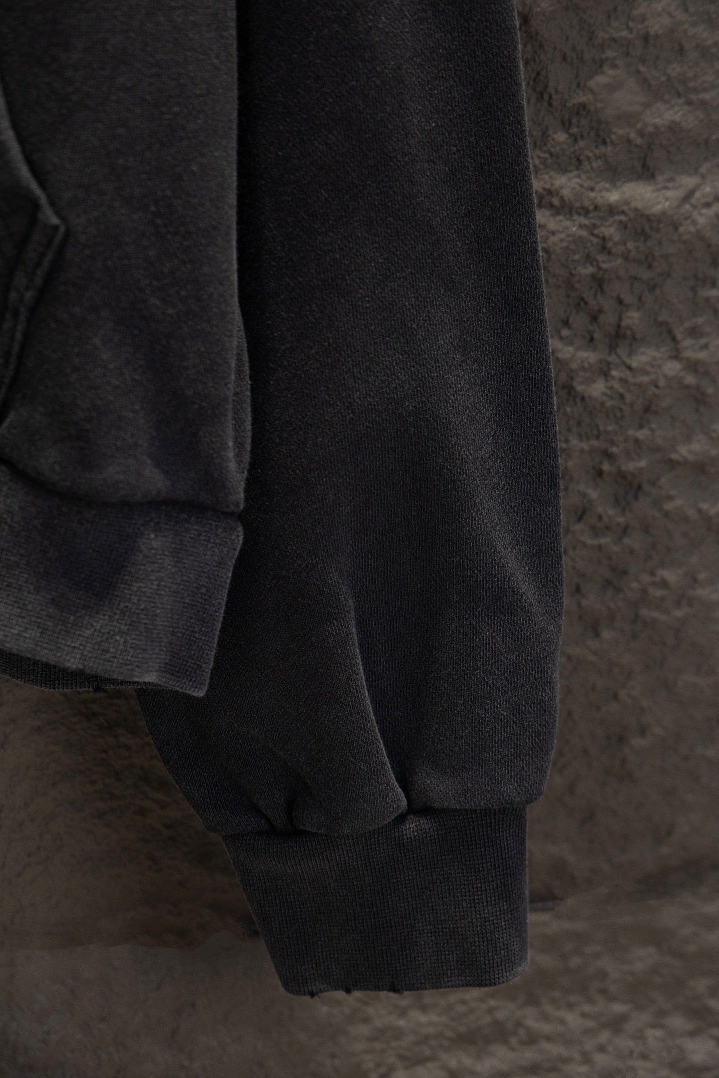 Balenciaga long zip-up hoodie lower sleeve and cuff, dark fabric with seam detail.