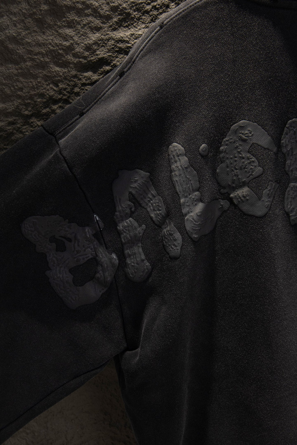Balenciaga long zip-up hoodie sleeve with embossed graphic pattern and snap details.