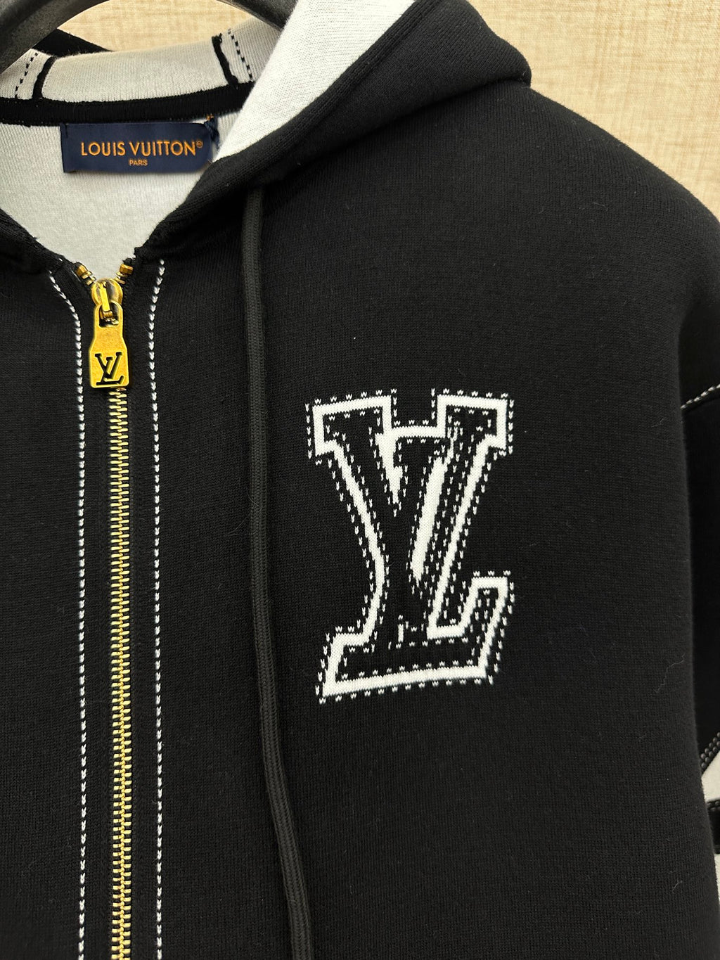 Hoodie hood and chest area with white LV-style logo patch and gold zipper