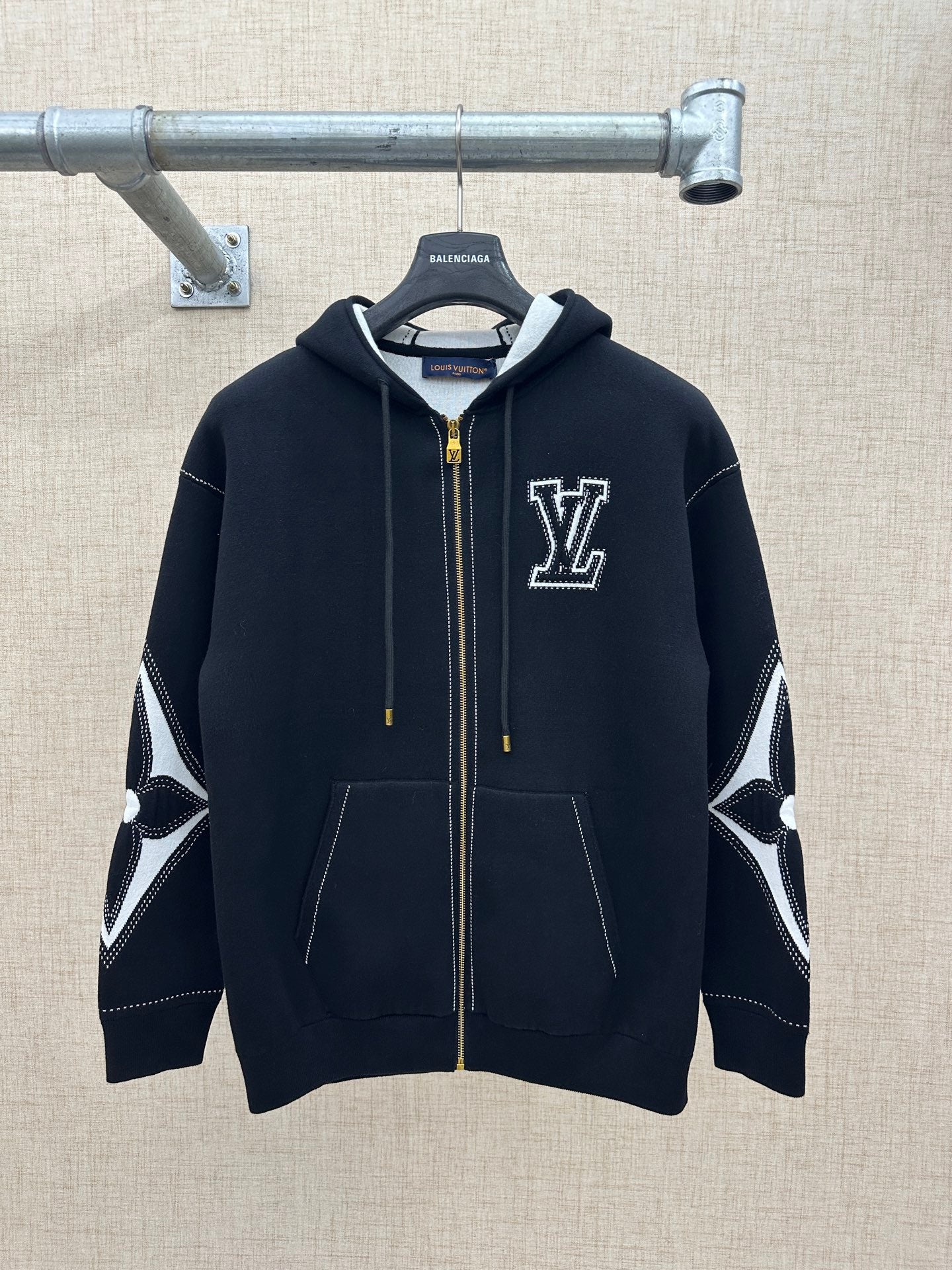 Zip-up hoodie with hood, dark knit, gold zipper, and LV-style chest logo patch