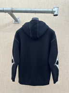 Back view zip-up hoodie with hood, dark knit, and contrast diamond sleeve graphic