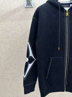 Zip-up hoodie sleeve with black-and-white diamond logo graphic and gold zipper