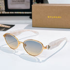 Gold round sunglasses with light blue tinted lenses and patterned medallion bridge