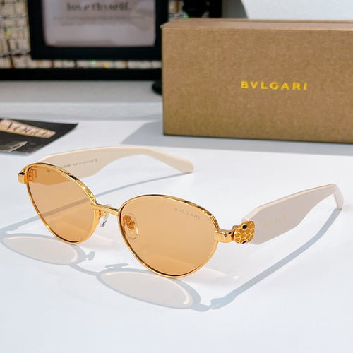 Gold round sunglasses with amber tinted lenses and sculpted medallion bridge detail