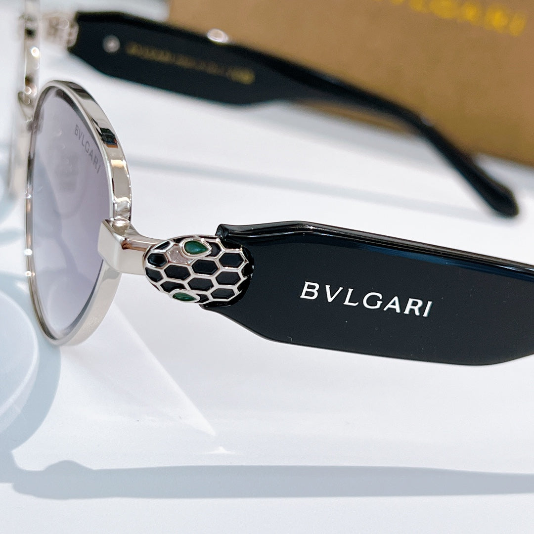 Round sunglasses with black temple arms, logo side text, and medallion hinge detail