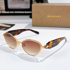 Tortoiseshell sunglasses with amber-pink lenses and gold metal medallion bridge