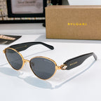 Gold-trim round sunglasses with dark lenses and black temple arms with logo