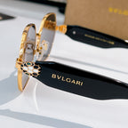 Gold-tone sunglasses side view with bee-detail hinge and black temple arm