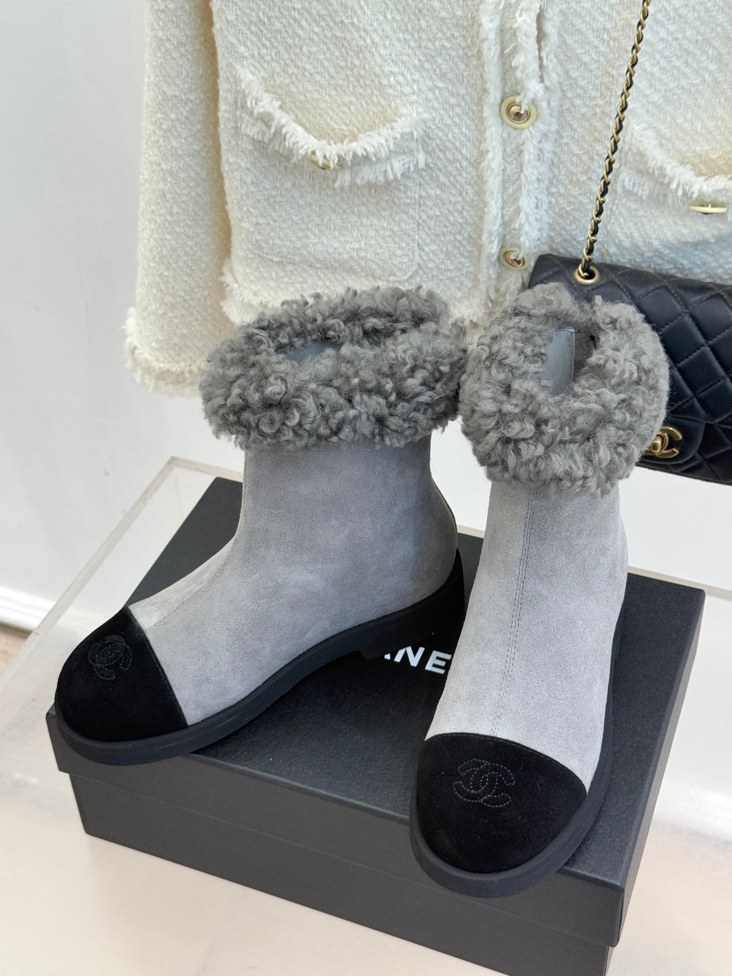 Pair of light gray suede ankle boots with fuzzy gray cuffs and black slip-on panels