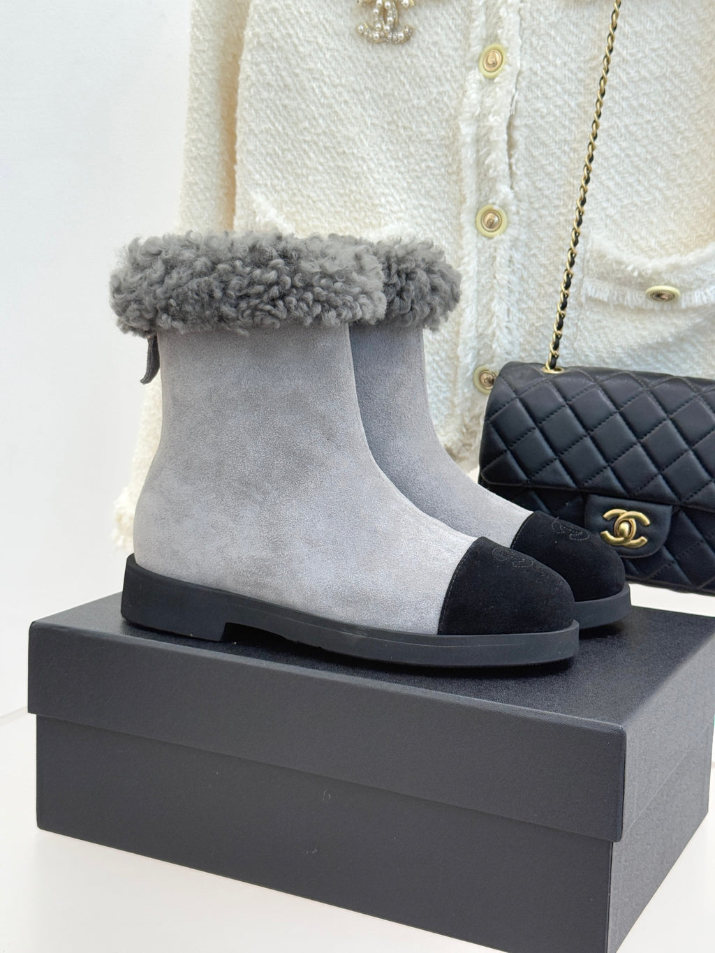 Light gray suede ankle boot with gray shearling cuff and black rubber sole