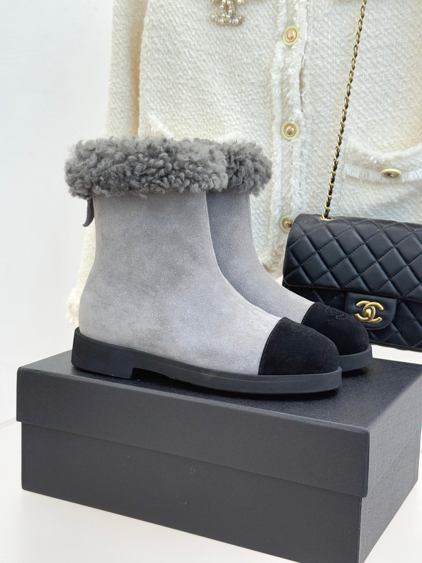 Light gray suede ankle boot with gray shearling cuff and black rubber sole