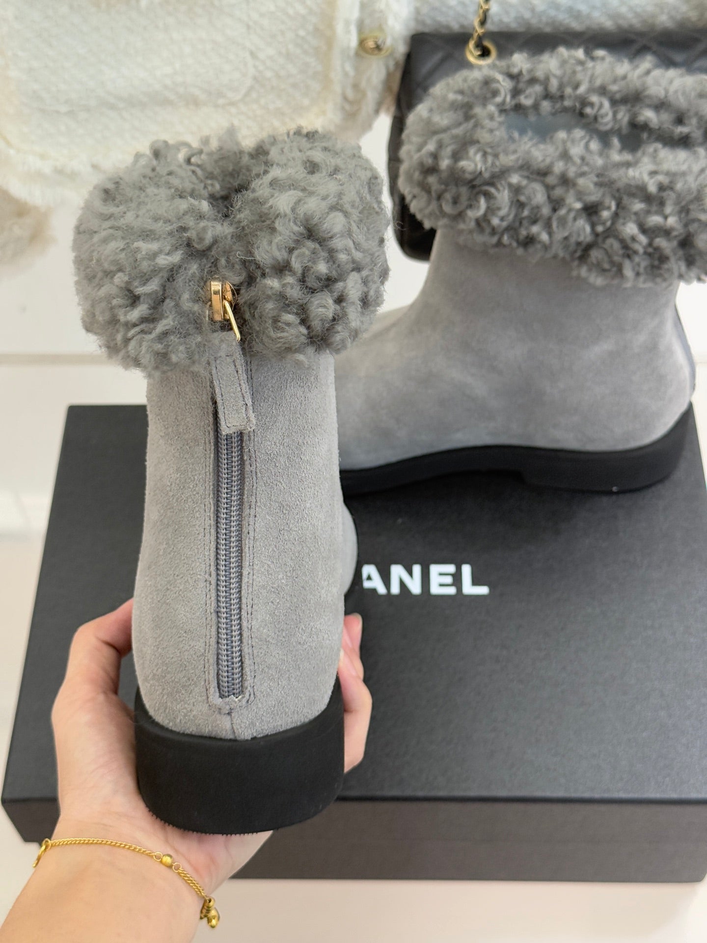 Light gray suede ankle boot with gray shearling cuff and side zipper pull