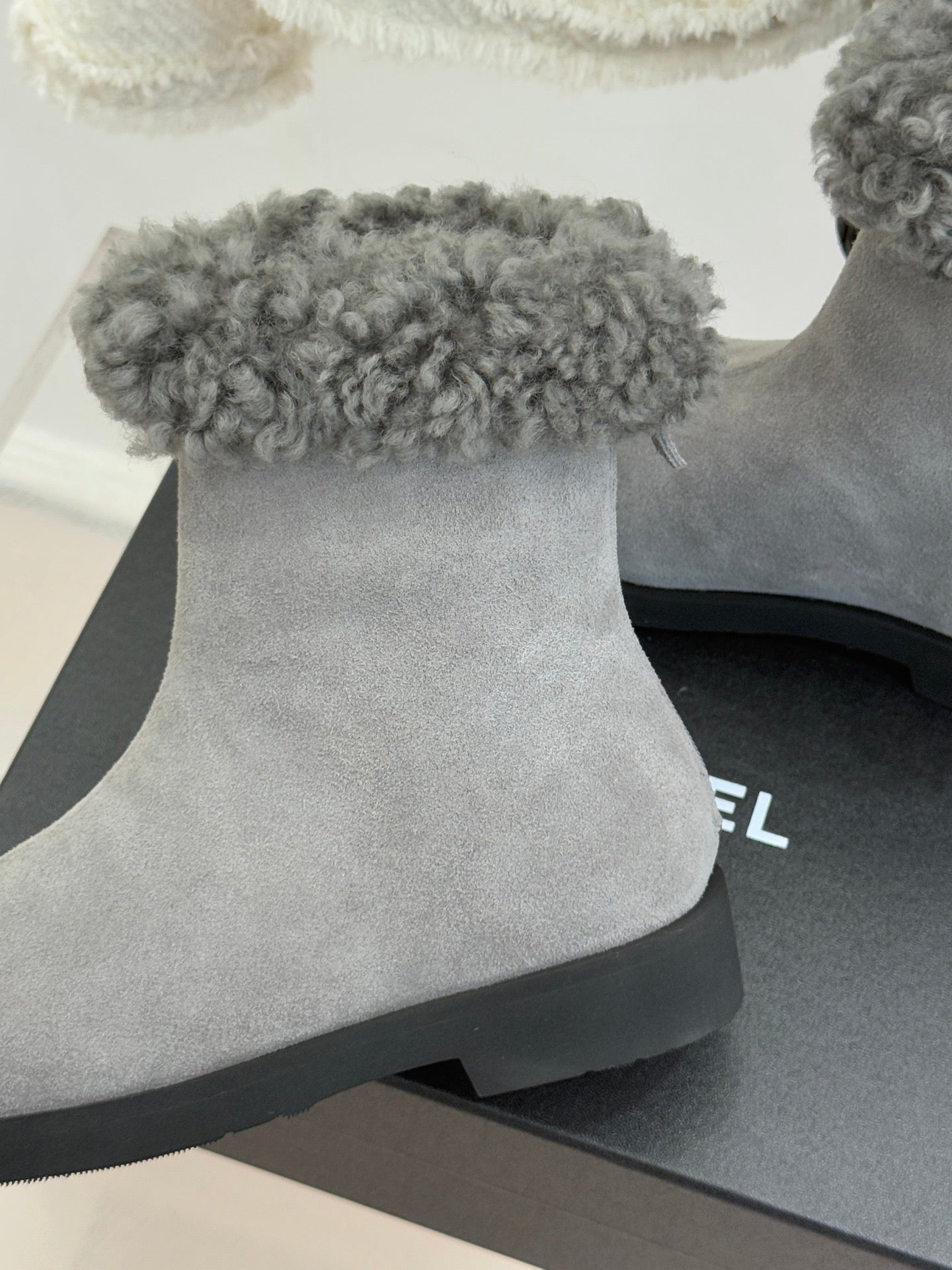 Light gray suede ankle boot with wide gray shearling cuff and black sole edge