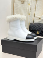 White women's ankle boots with black side panel and fluffy shearling cuff