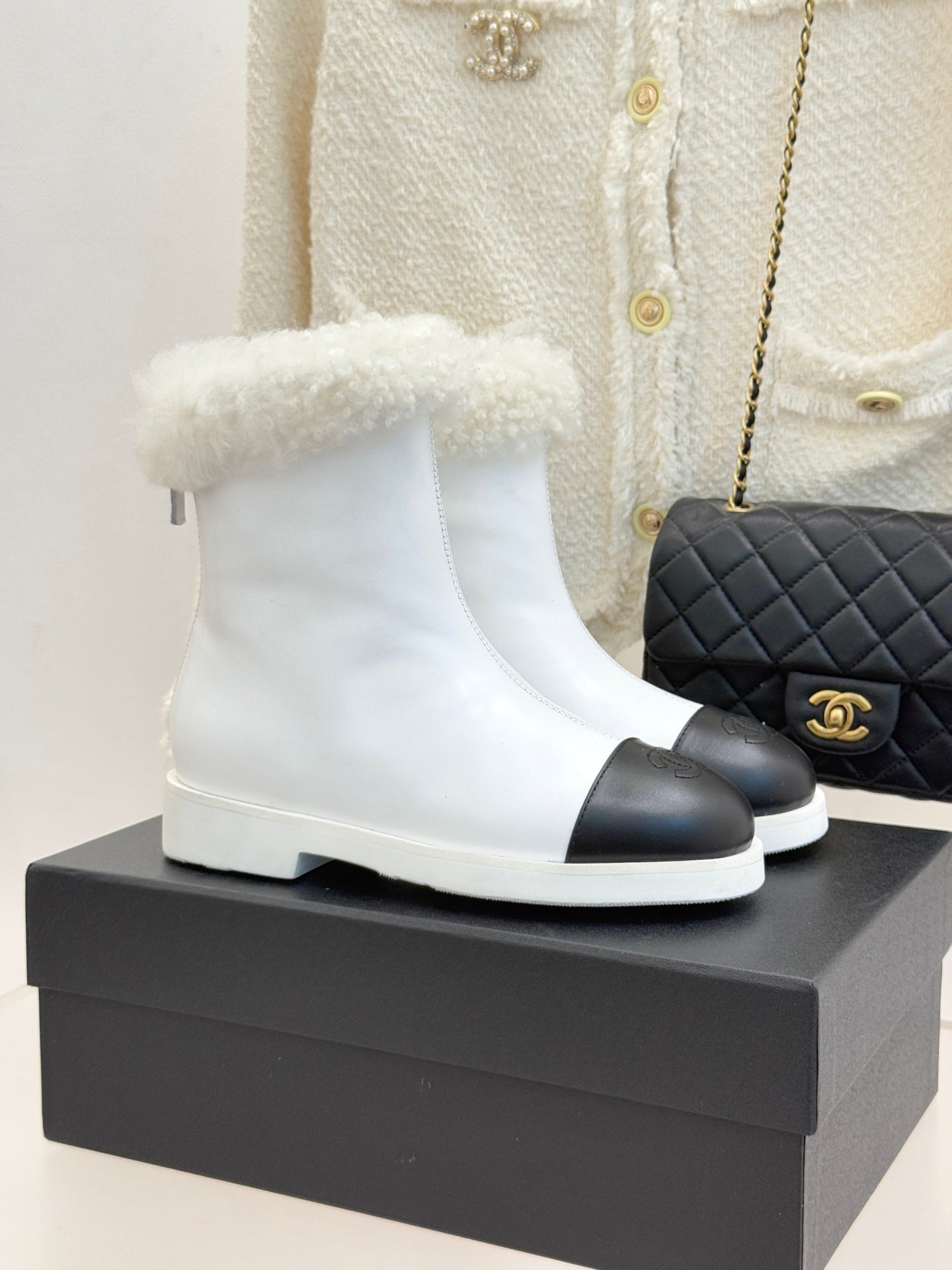 White women's ankle boots with black side panel and fluffy shearling cuff