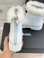 White women's ankle boot with side zipper and fluffy shearling cuff, heel view