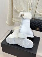 White women's ankle boots with shearling cuff and black side insert, sole view
