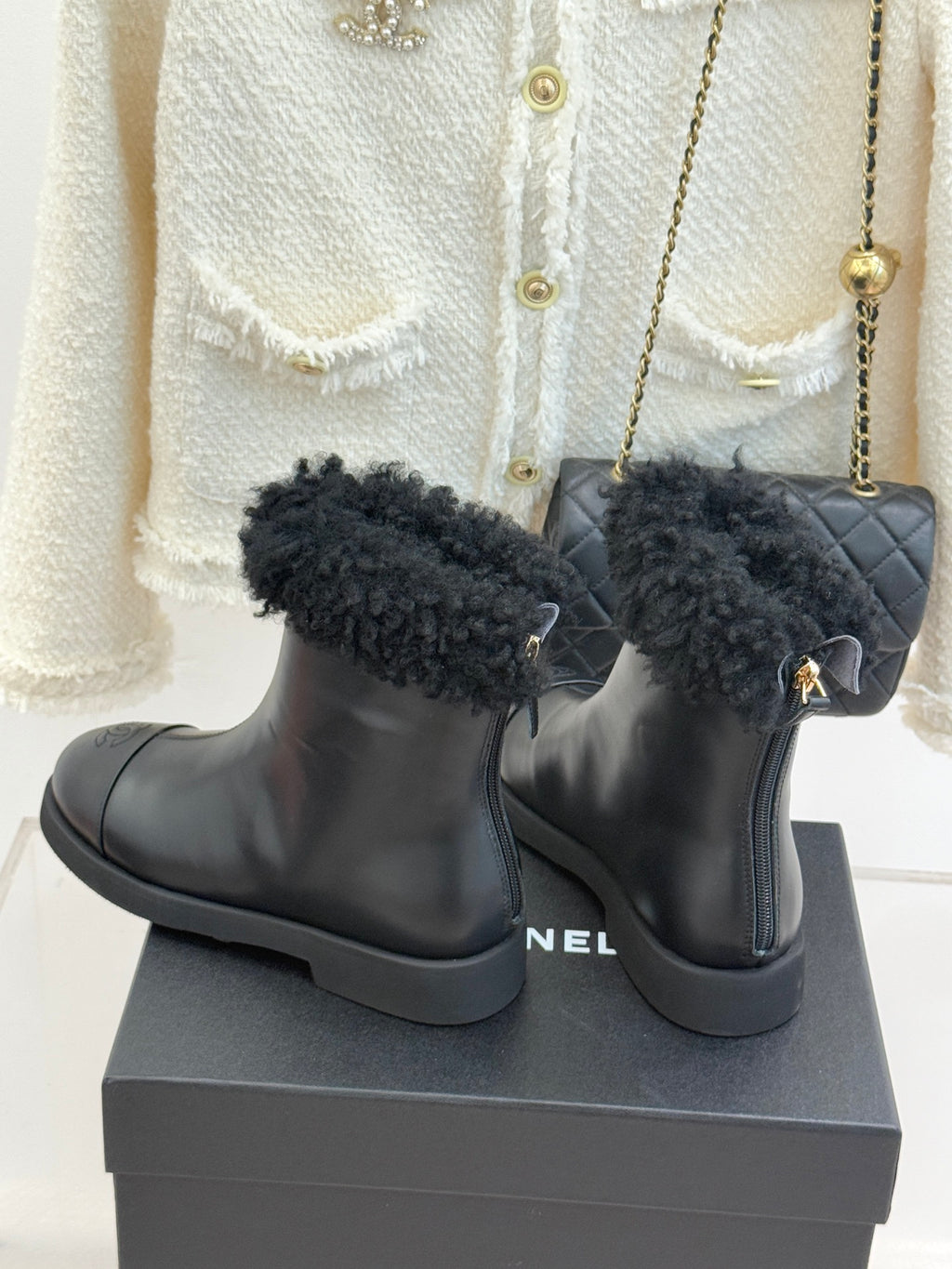 Black leather ankle boots with black faux-fur cuffs and ankle tab zipper pull